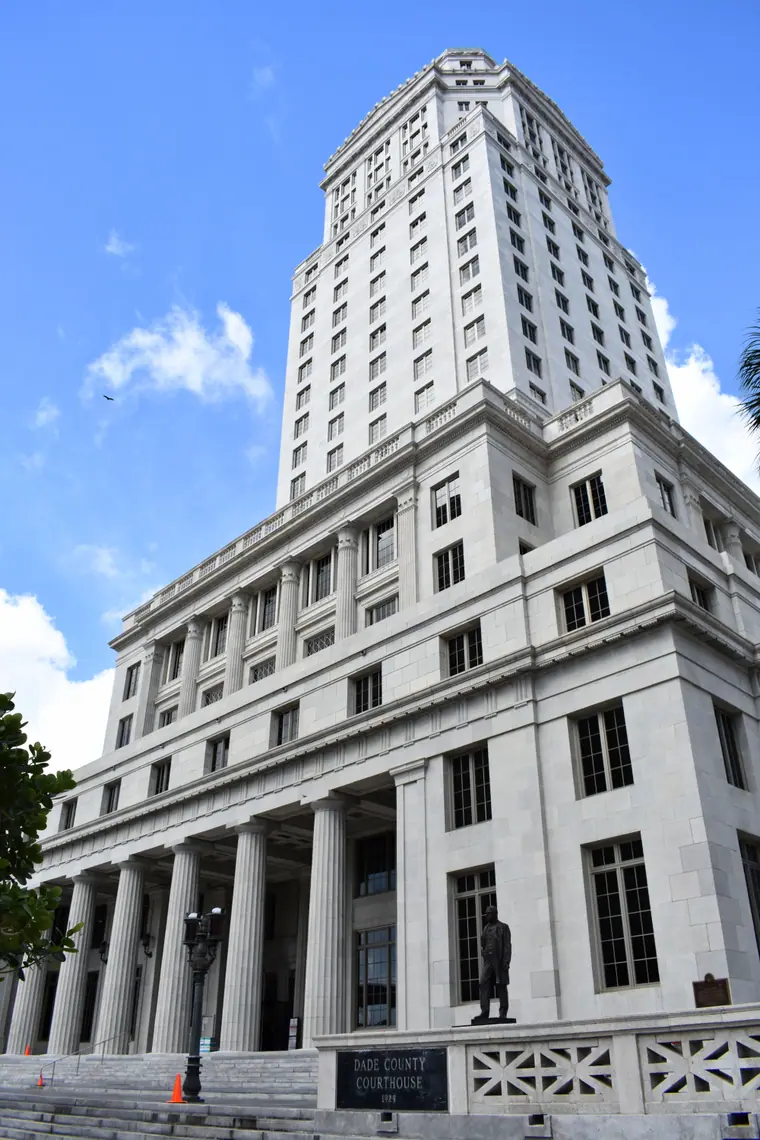 The tower of the historic Dade County Courthouse in downtown Miami rising above surrounding buildings.
