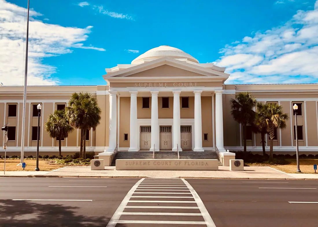 The full front elevation of the Florida Supreme Court Building, a limestone building with a portico and central dome.